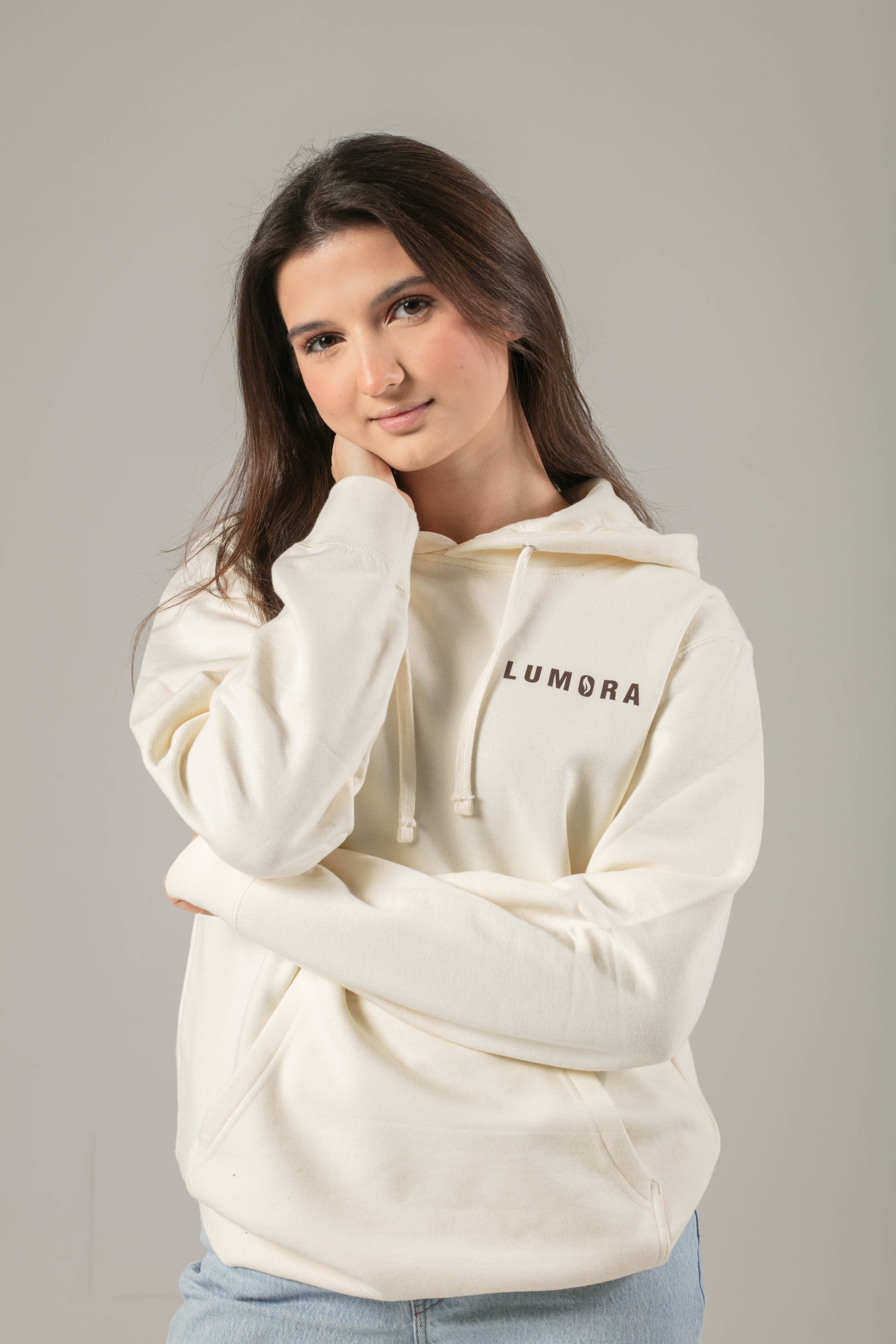 Ivory hoodie with Lumora logo on front and Child of God design on back.